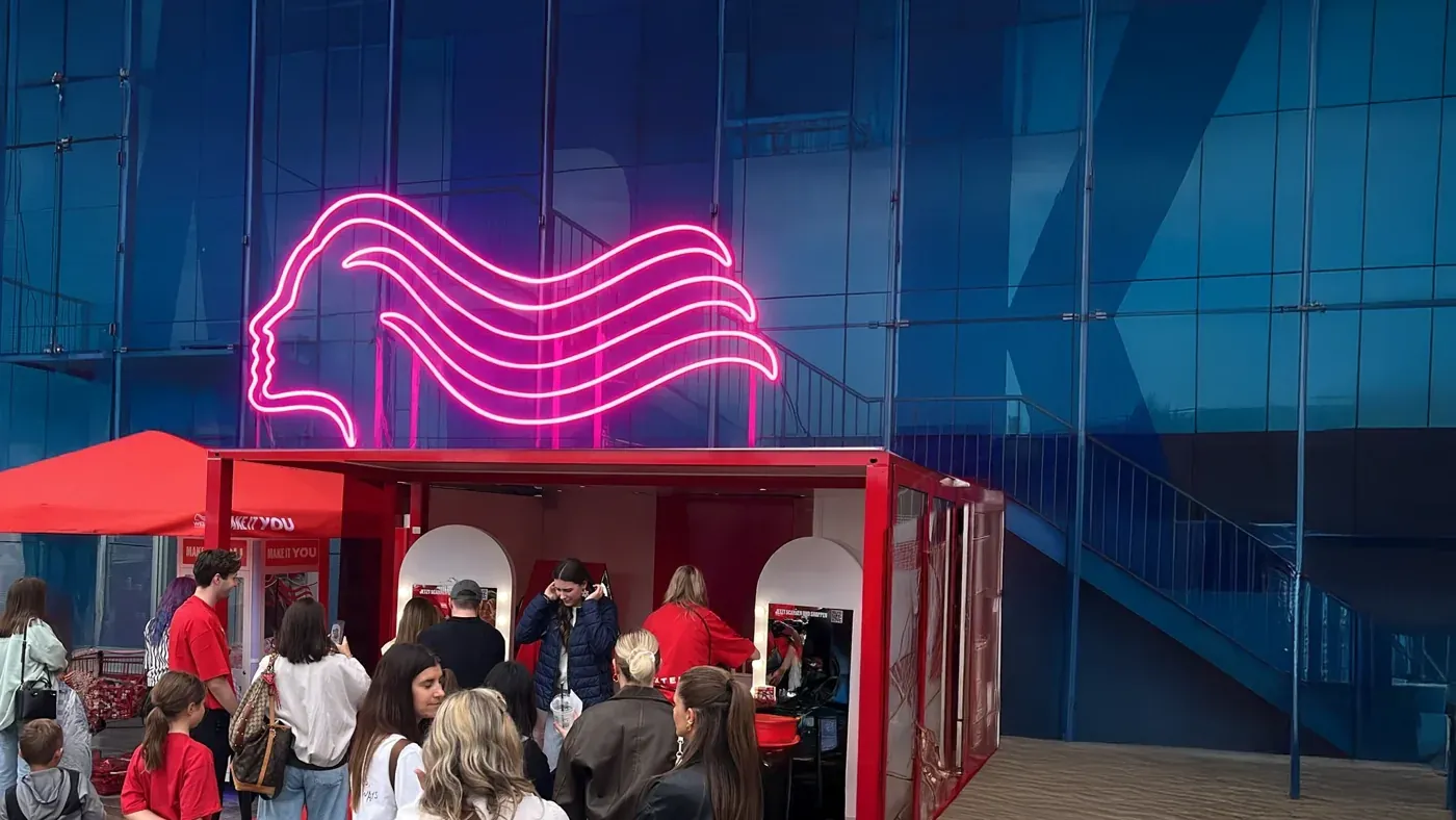 Leuchtendes Wella-Logo an einem Eventstand